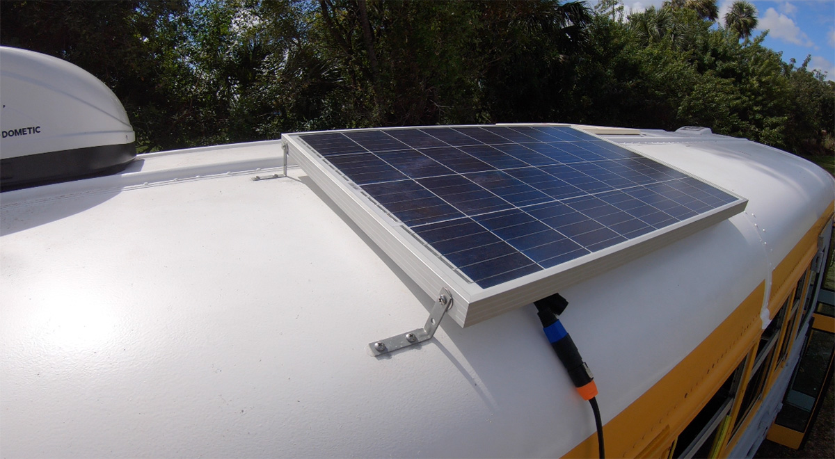 a solar panel mounted on the tilting roof of a skoolie